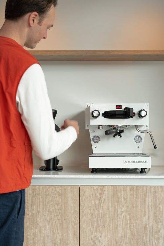 Man loopt naar La Marzocco machine